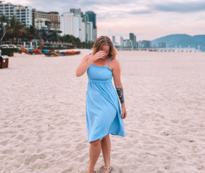 Linda on the beach in a blue dress